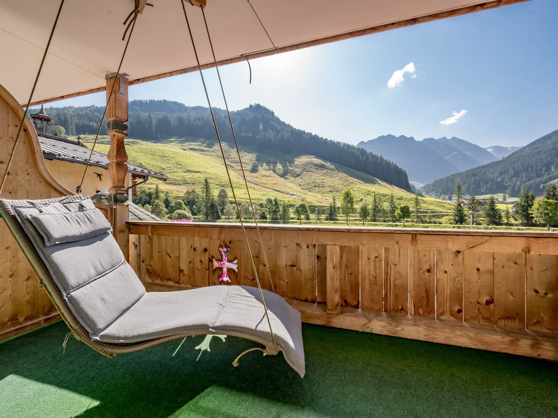 Der Grubacher • Biohotels in Gerlos im Zillertal in Tirol Hängeschaukel auf einem Balkon mit Bergblick im Sommer