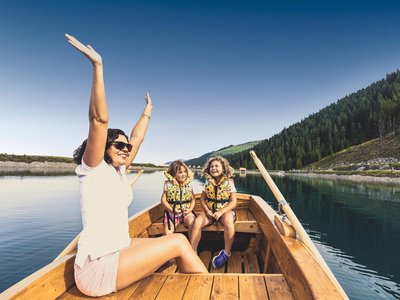 Der Grubacher • The best choice among the eco hotels in Tyrol Happy woman with children in a rowboat on a lake