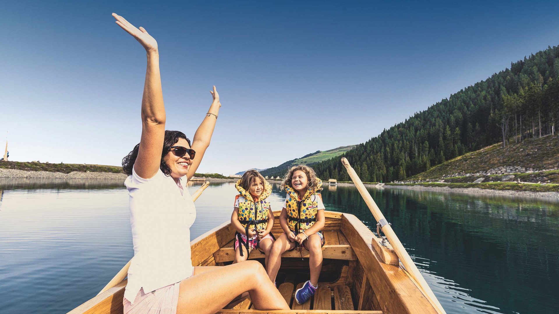 Sommerglück in Gerlos • Der Grubacher: Sommerurlaub Zillertal Glückliche Frau mit Kindern in einem Ruderboot auf einem See