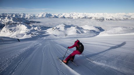 Pictures & Impressions • Der Grubacher: Hotel in Gerlos Skier glides over freshly groomed slopes amidst a spectacular mountain landscape