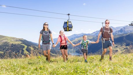 Pictures & Impressions • Der Grubacher: Hotel in Gerlos Family hiking on a mountain meadow with a cable car