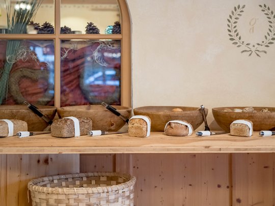 Eating on holiday in Gerlos • Der Grubacher: Eco Hotel in Tyrol Breakfast buffet with loaves of bread on a large cutting board