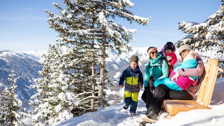 Pictures & Impressions • Der Grubacher: Hotel in Gerlos Family takes a break on a winter hike with a view of the snowy Alpine landscape