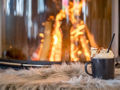Der Grubacher • The best choice among the eco hotels in Tyrol Cocoa with whipped cream in front of a burning tiled stove