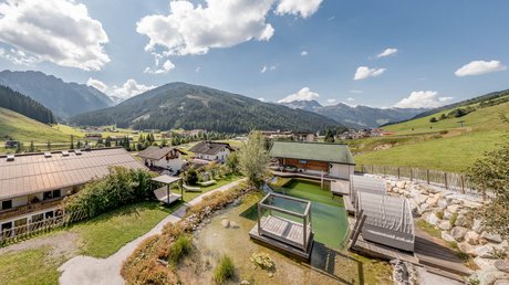 Pictures & Impressions • Der Grubacher: Hotel in Gerlos Natural swimming pond with sunbathing area on a sunny summer day