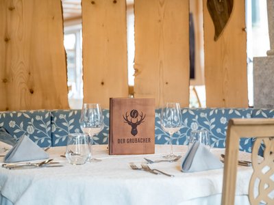 Eating on holiday in Gerlos • Der Grubacher: Eco Hotel in Tyrol Set table in the restaurant with a menu
