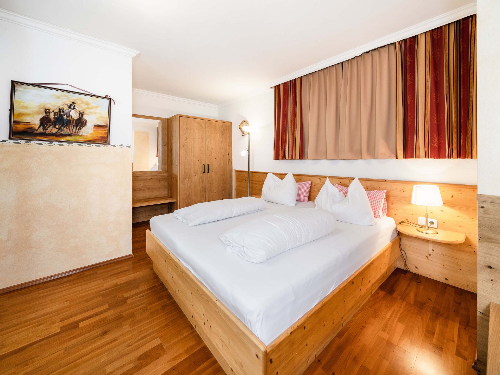 Der Grubacher • The best choice among the eco hotels in Tyrol Bedroom with double bed and parquet flooring with built-in wardrobe