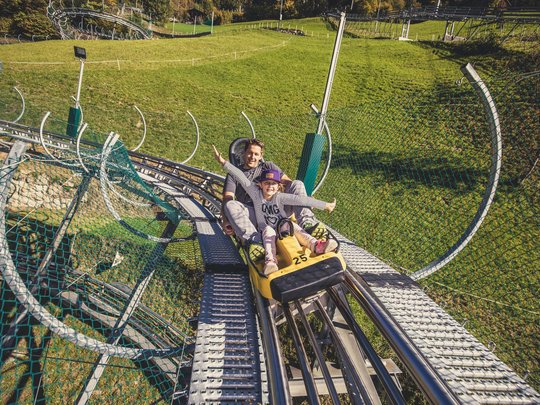 Erlebnisse im Zillertal • Der Grubacher: Biohotel in Gerlos Mann mit Kind auf dem Arena Coaster in Zell am Ziller