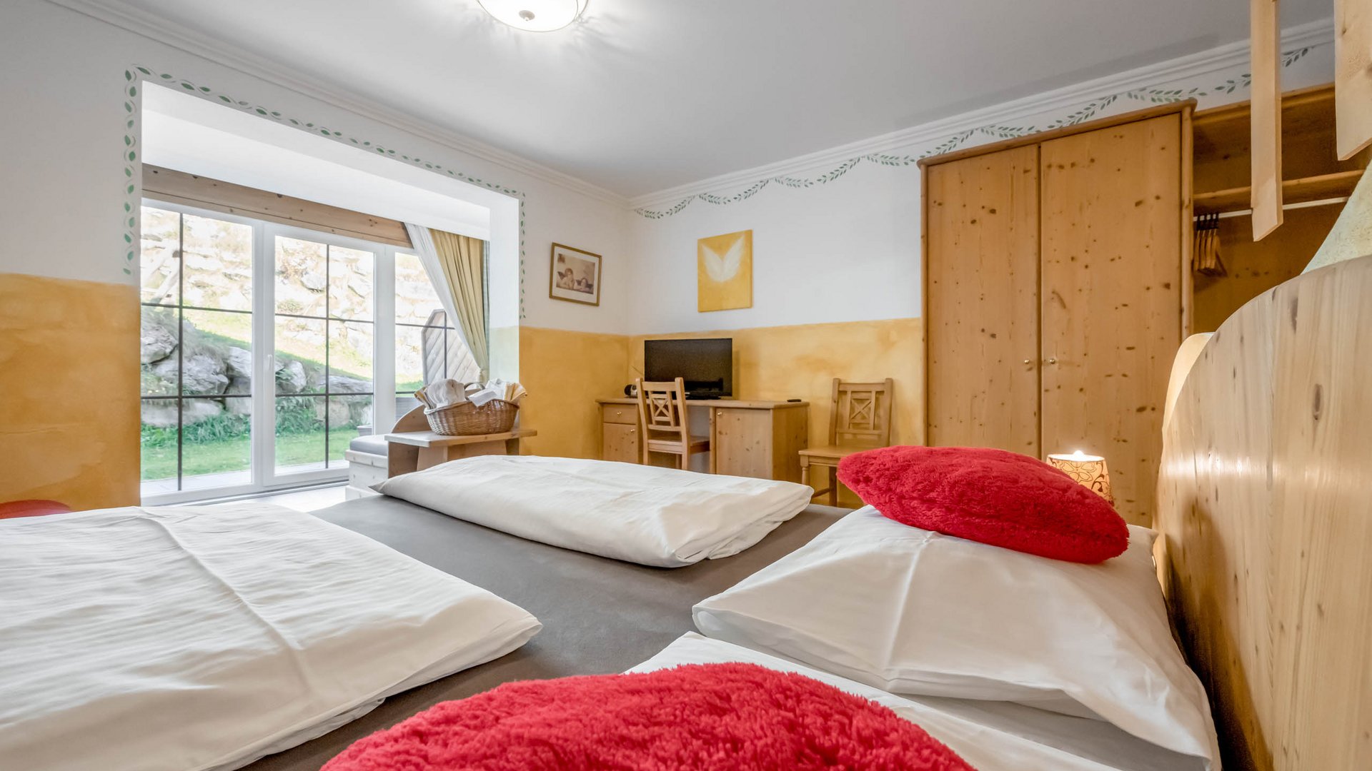 Hotelzimmer mit Doppelbett, Schreibtisch mit TV und Terrasse mit Garten