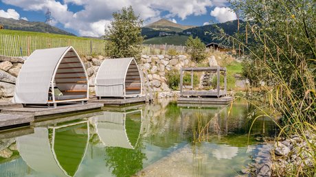 Pictures & Impressions • Der Grubacher: Hotel in Gerlos Swimming pond in the garden with a sun lounger and a view of the mountains