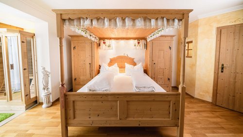 Hotel in Gerlos im Zillertal: Preise Himmelbett in einem Hotelzimmer mit Parkettboden und Teppich