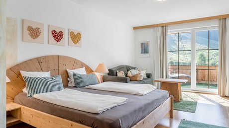 Pictures & Impressions • Der Grubacher: Hotel in Gerlos Hotel room with double bed, pictures made of dried flowers, and balcony
