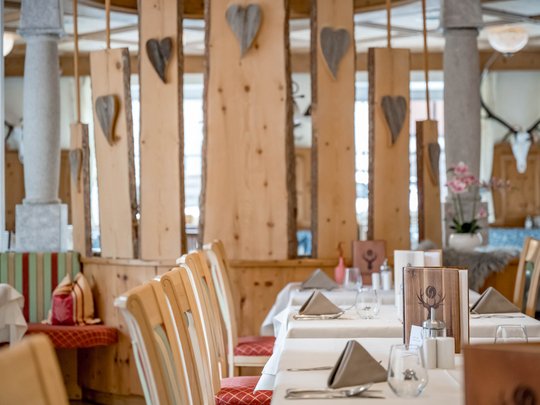 Eating on holiday in Gerlos • Der Grubacher: Eco Hotel in Tyrol Restaurant with set tables and wooden decorations