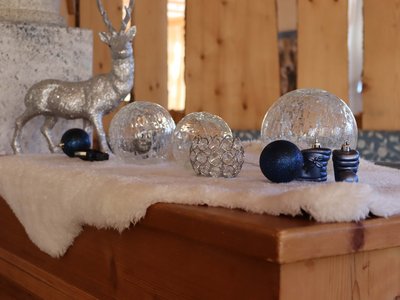 Familienurlaub im Zillertal • Der Grubacher: Hotel in Tirol Glitzernde Winterdeko mit silbernem Rentier und Kugeln auf flauschigem Untergrund