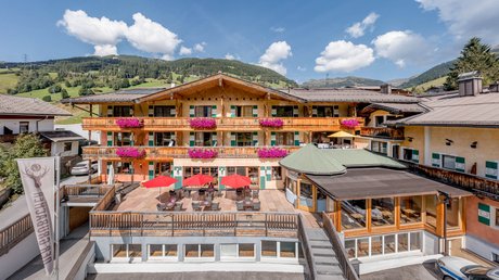 Pictures & Impressions • Der Grubacher: Hotel in Gerlos Exterior facade of Hotel Grubacher with balcony flowers in summer